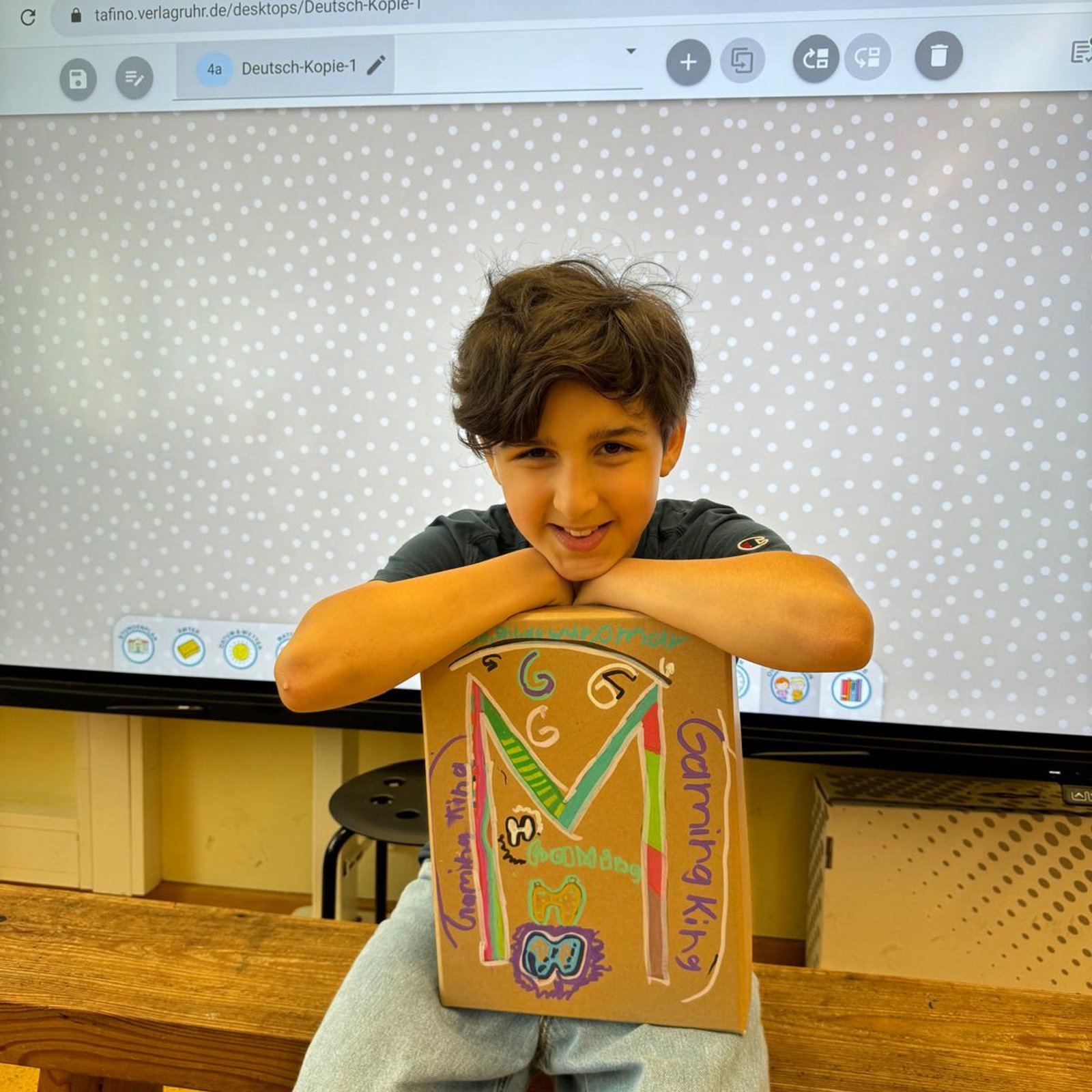 Schüler mit Karton-Kunstwerk